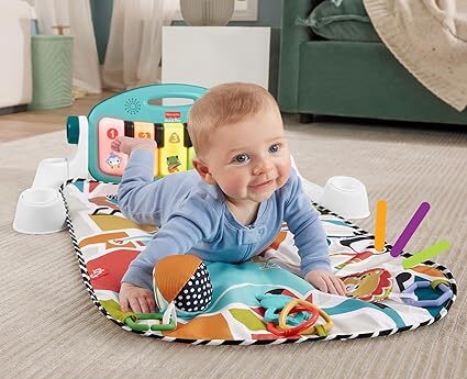 baby is joyfully playing with Fisher-Price Kick & Play Piano Gym one of
the best sensory toys of babies and toddlers .
